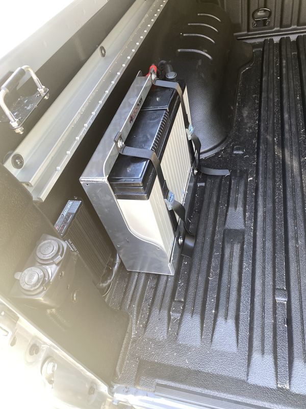 A closer view of the auxiliary battery bracket, showing the cable runs down the side of the ute tub.